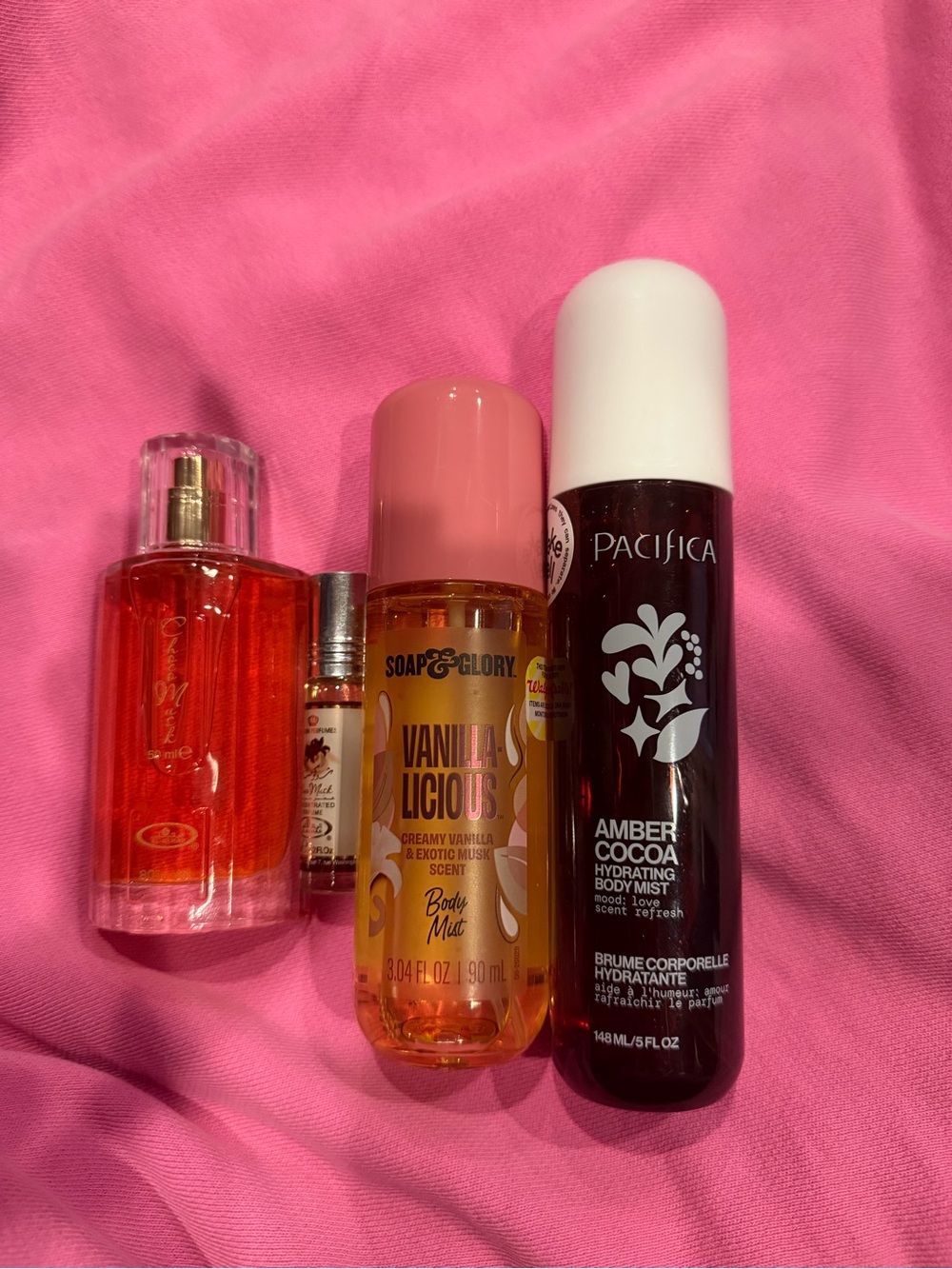 Pacifica Amber Cocoa Hydrating Body Mist in Dark Brown with White Cap on Pink